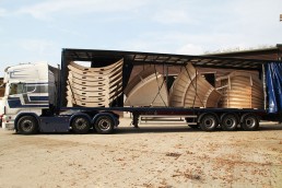 Articulated lorry with sides open, loaded with modular sections of a skatepark install